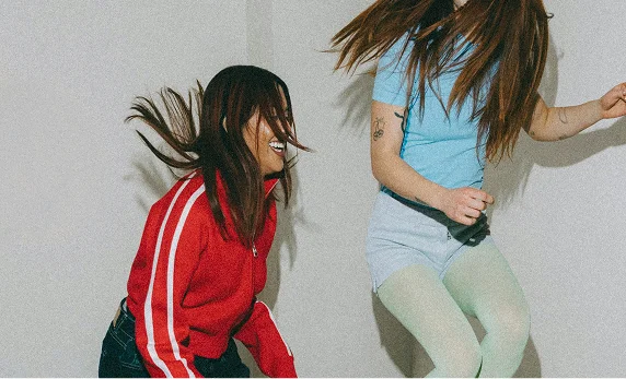 two girls jumping happily